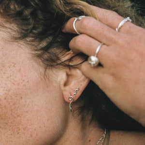 model wearing small silver wavy stud earrings