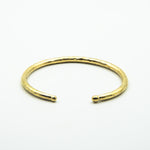 thick brass cuff with balled ends, front view on white background