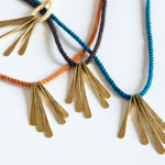 Various silk rope necklaces with brass pendants