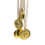 Stamped brass circle pendant with sterling silver chain on white background
