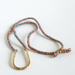 U shaped hand carved pendant on blue orange silk rope