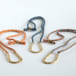 Various U shaped hand carved pendants on silk rope