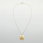 top view of brass cutout sheet pendant on silver chain necklace