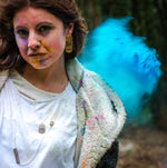 model wearing silver and brass necklace with powder cloud behind