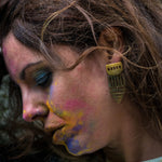 model wearing long brass geometric cutout earrings