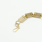 cutout brass pieces bracelet clasp detail on white background