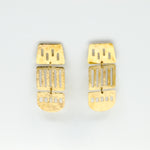 long brass cutout earrings on white background
