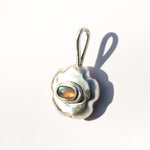 Pendente de prata em forma de flor com uma pedra preciosa de labradorita sobre um fundo branco