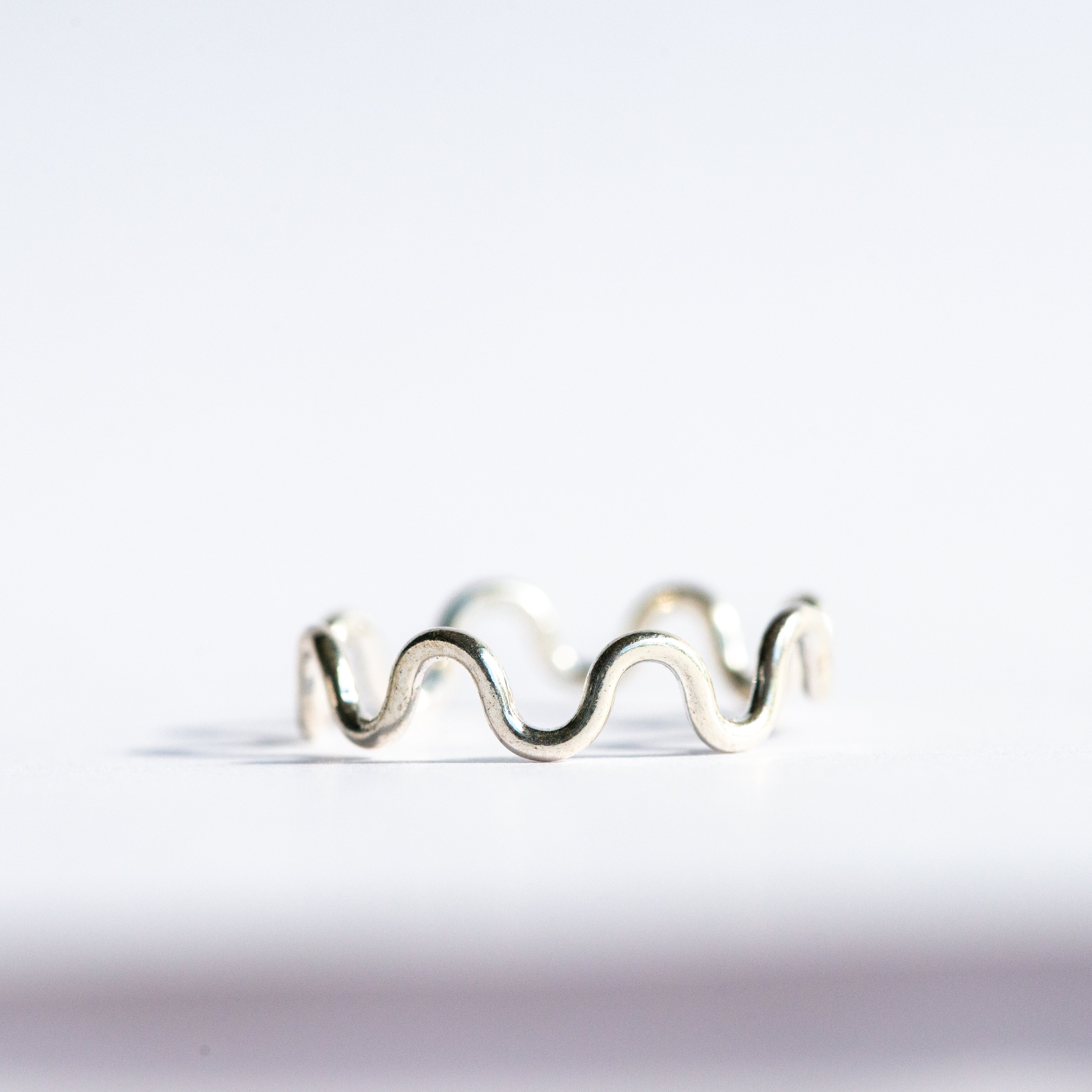Silver wavy ring on a white background