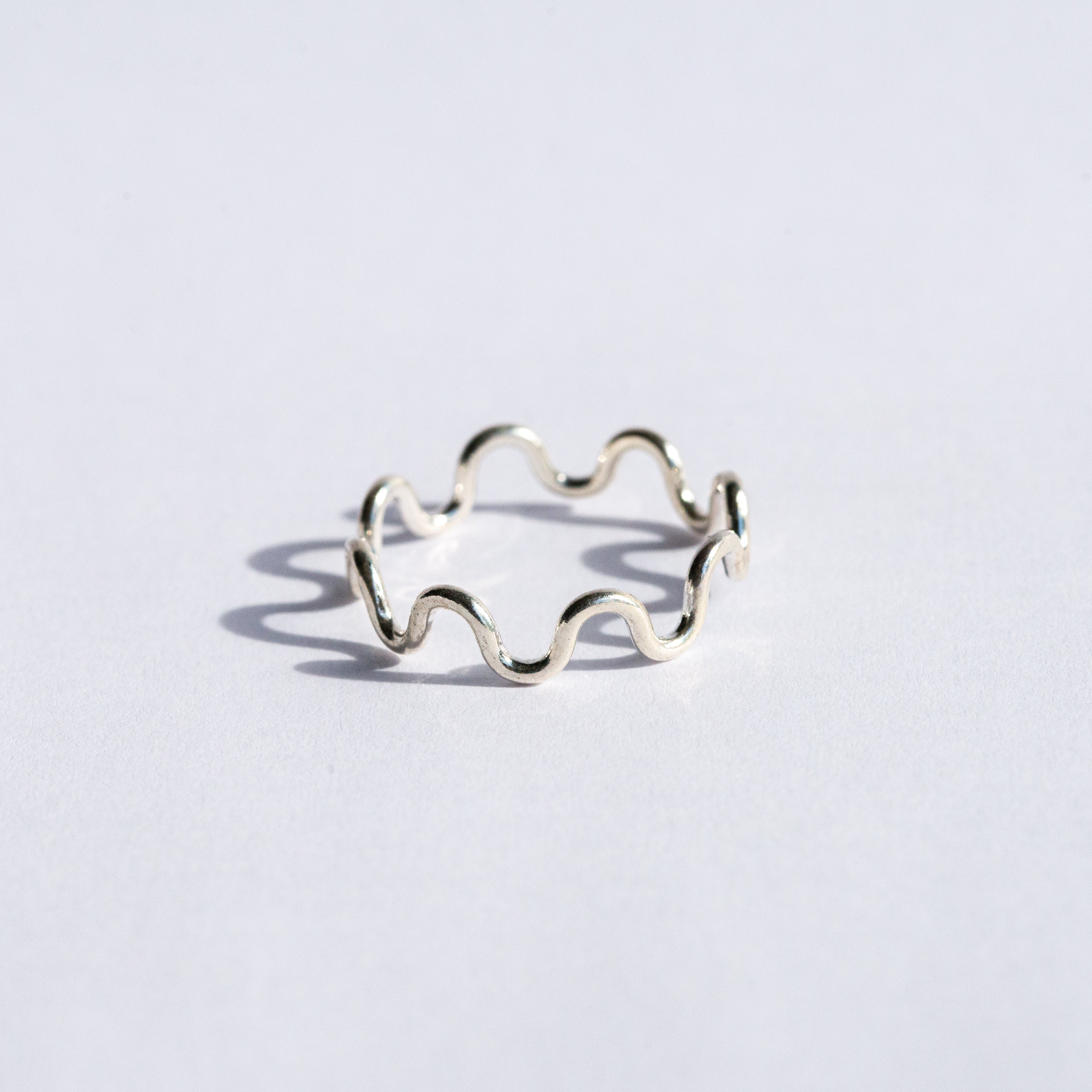 Silver wavy ring on a white background