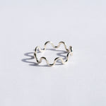Silver wavy ring on a white background