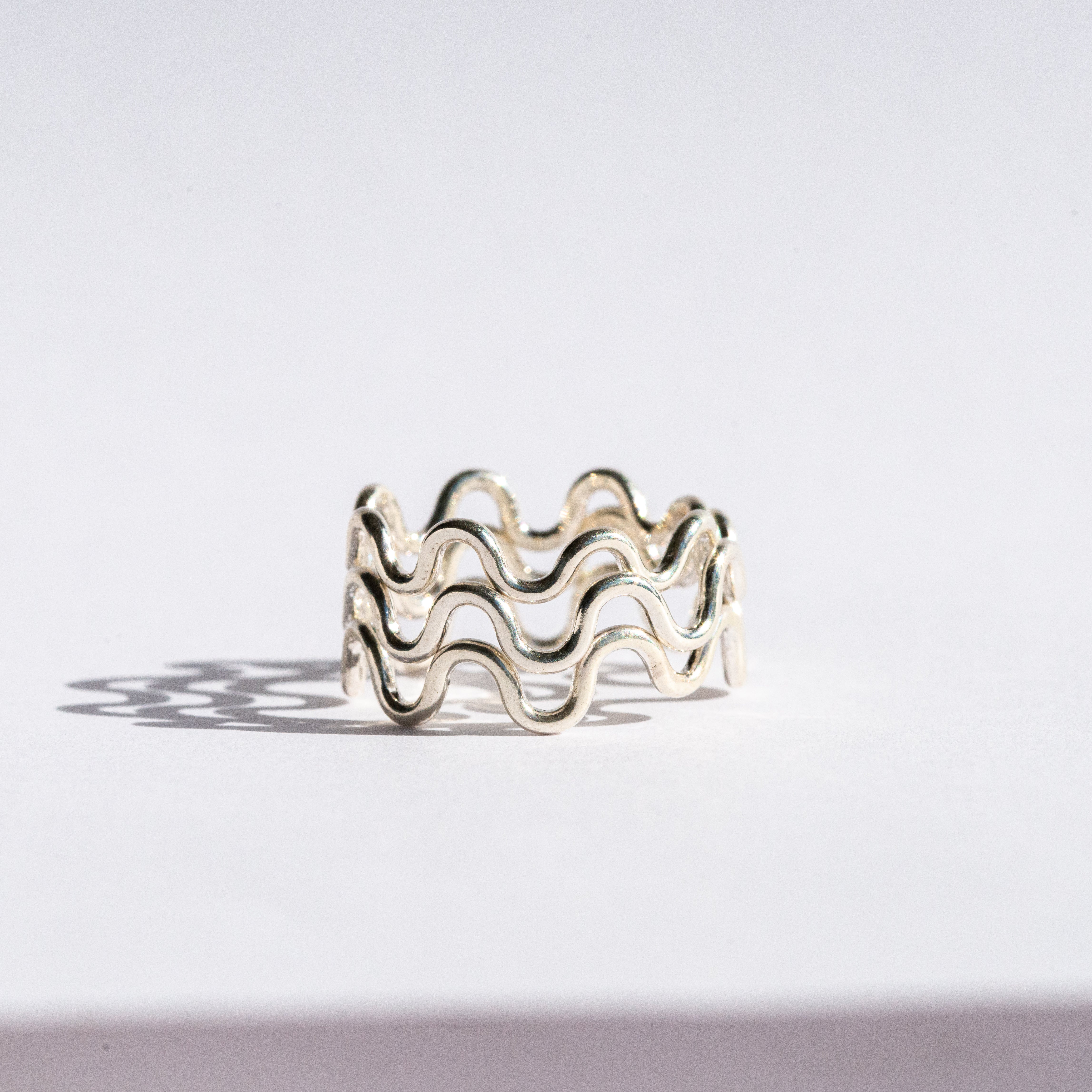 silver ring with wavy design on a white background