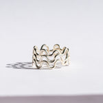 silver ring with wavy design on a white background