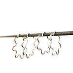 Silver wavy hoops on a thin rod against a white background