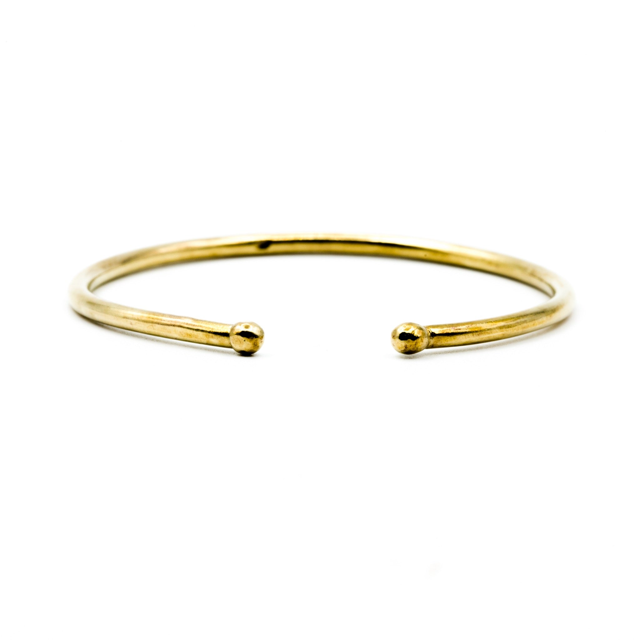 brass cuff with balled ends on white background