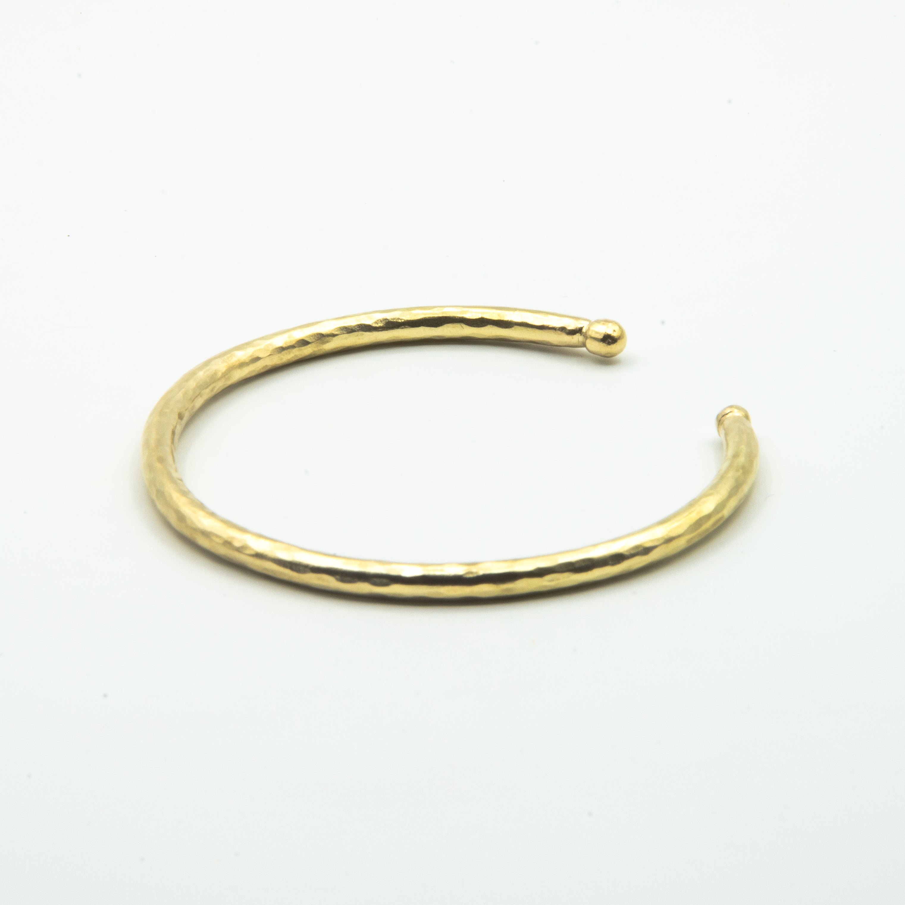 thick brass cuff with balled ends, back view on white background