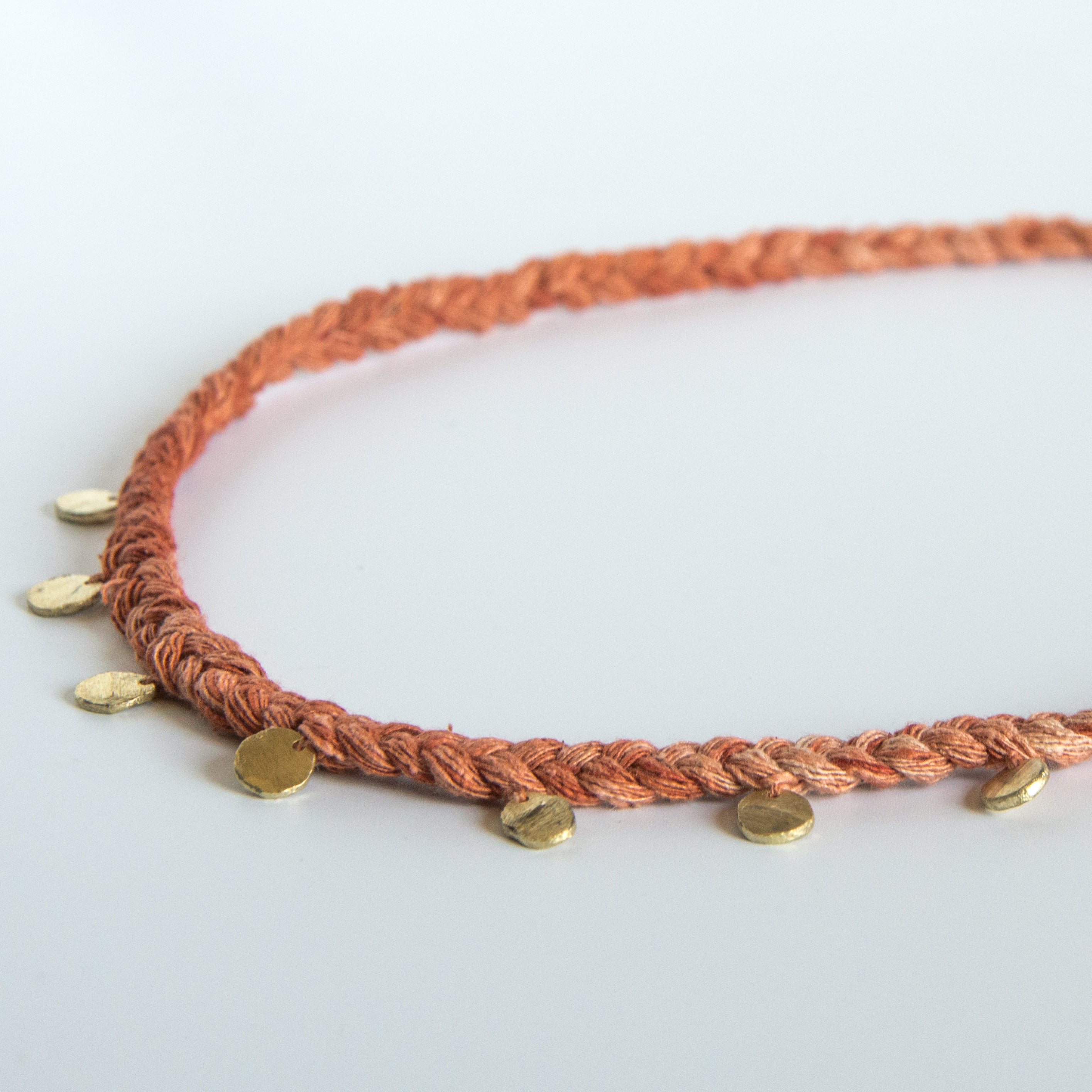 Orange silk braid necklace with seven circle pendants close up