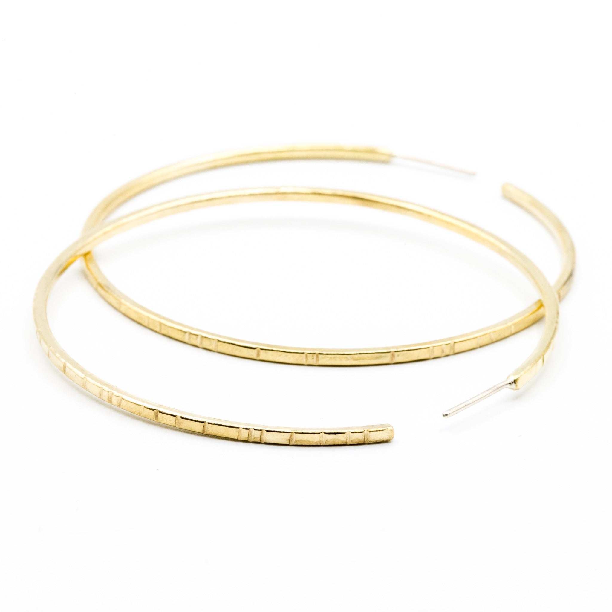 big brass hoops with lined details on white background