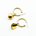 boobie shaped brass dangly hoops on white background