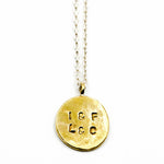 Stamped brass circle pendant with sterling silver chain on white background