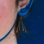 Model wearing brass tassel earrings