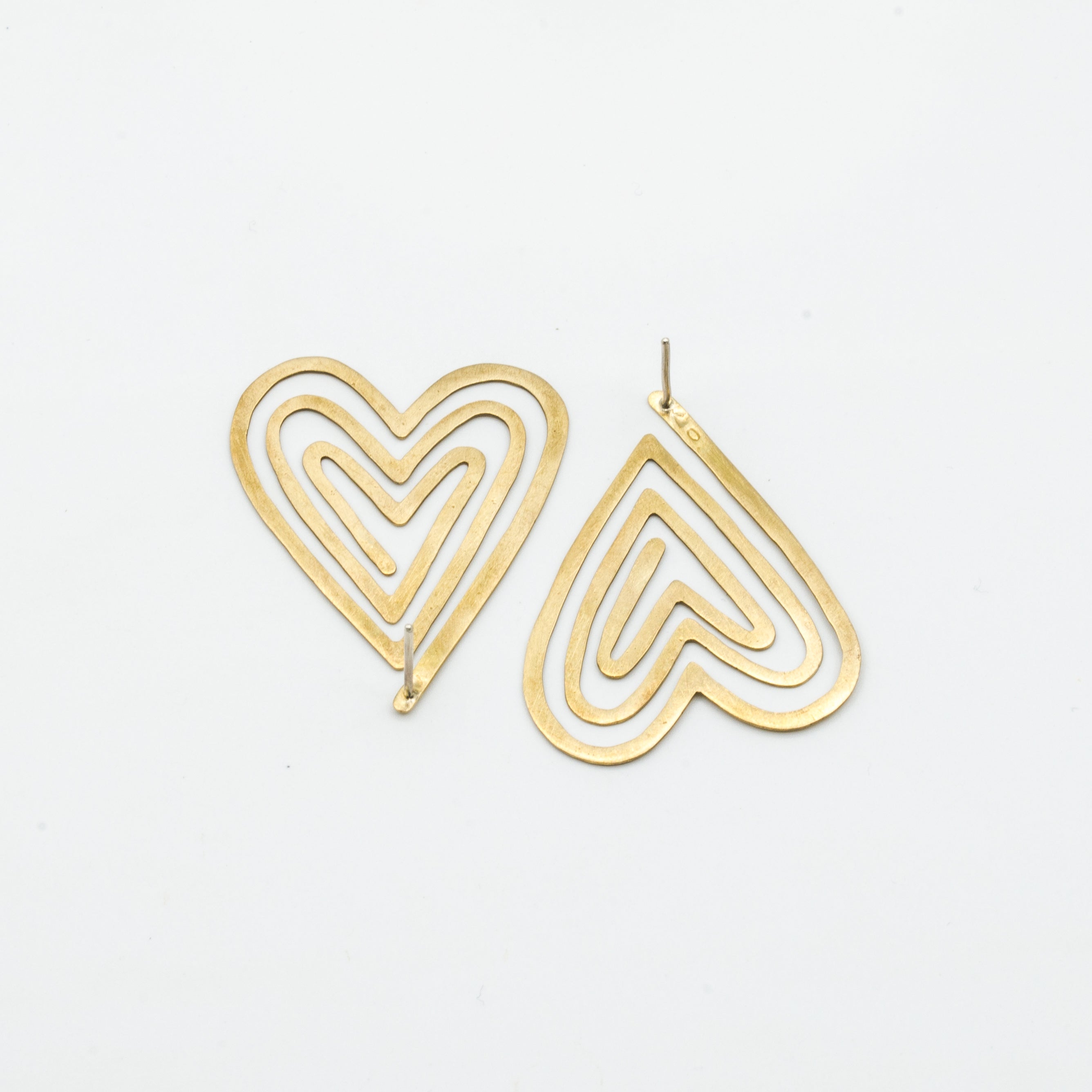 top view of backside of heart shaped stud earrings on white background