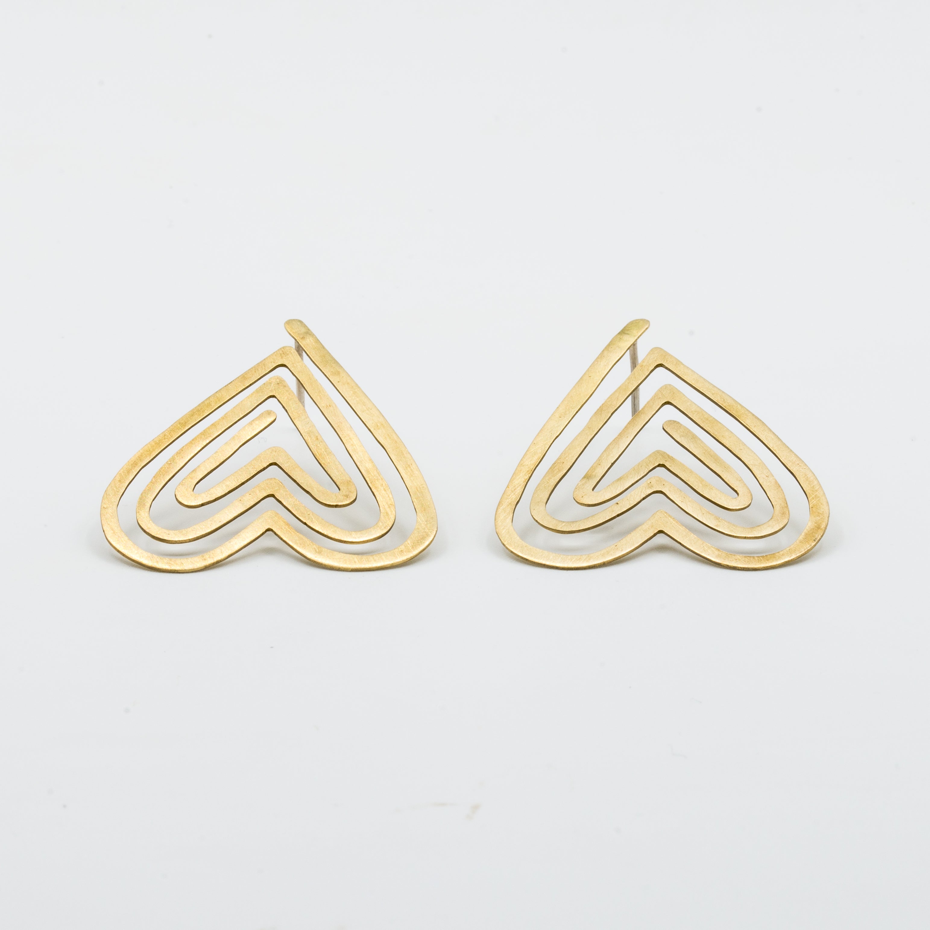 angled view heart shaped stud earrings on white background