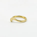 side view of hand forged curved brass ring on white background