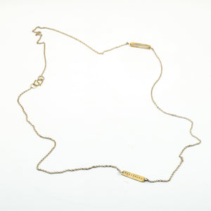 top view of brass cutout pieces on silver chain necklace