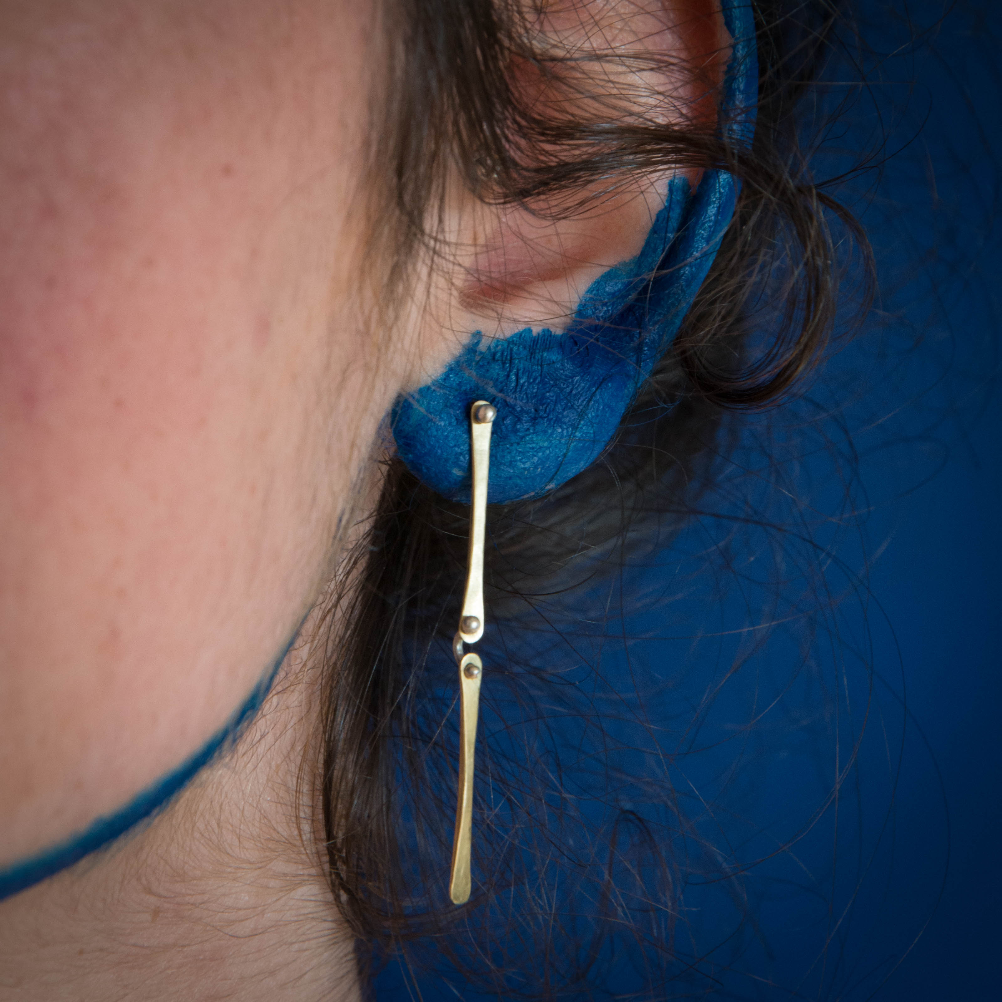 Model wearing delicate brass earrings