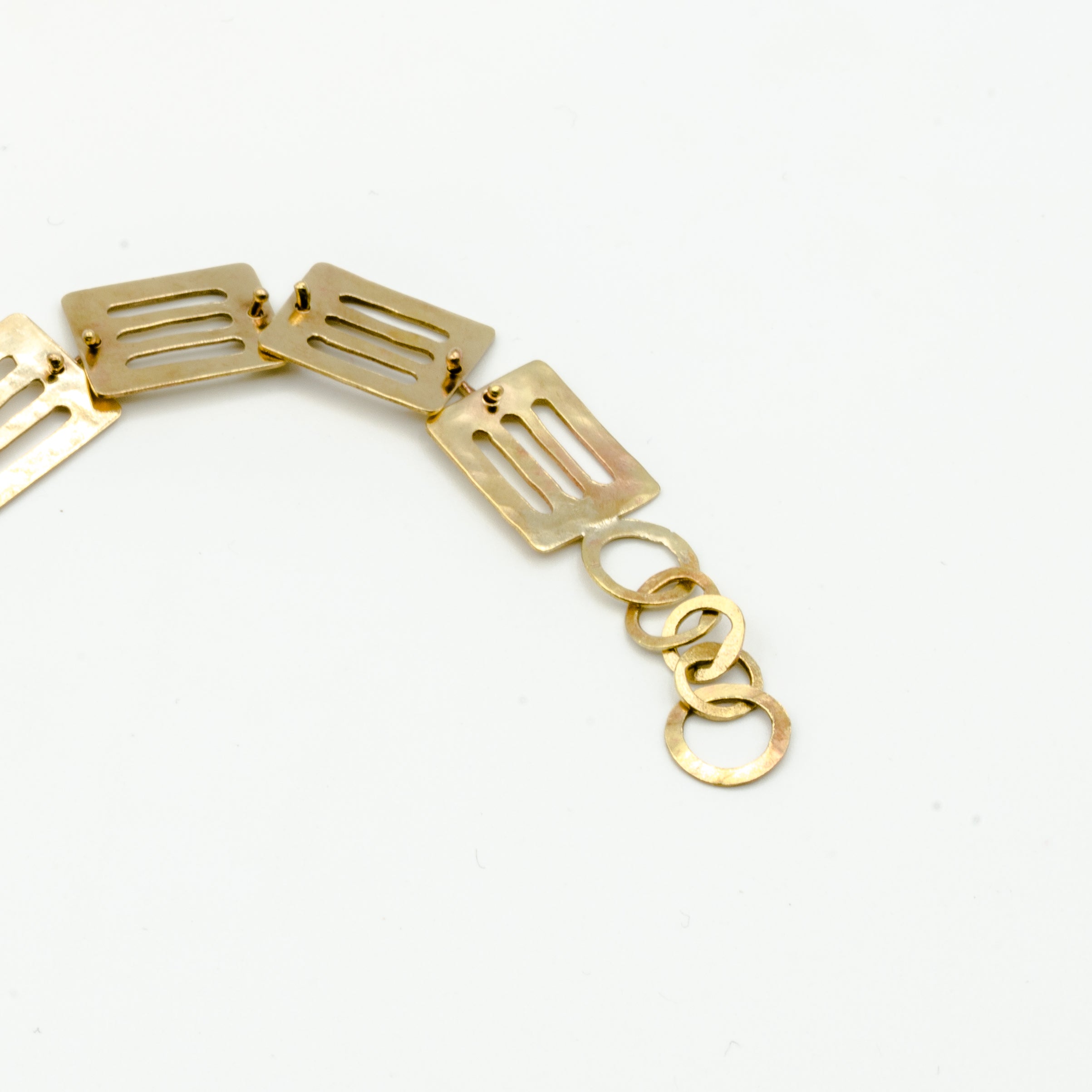 cutout brass pieces bracelet clasp detail on white background