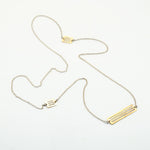 silver chain with brass cutout pieces necklace on white background