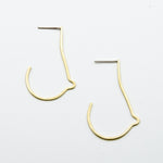 breast shaped brass wire earrings on white background top view