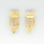 long brass geometric cutout earrings on white background